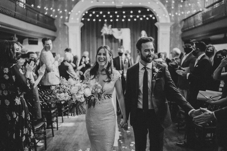bride and groom recess down the aisle at the end of their wedding ceremony at the Great Hall in Toronto